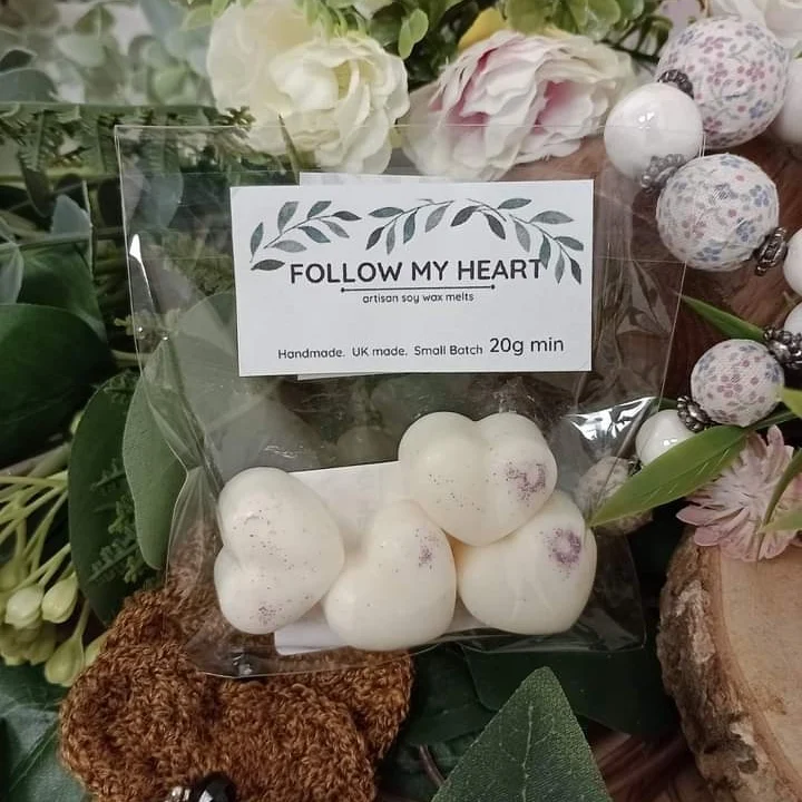 A pack of robson's retreat wax melts on greenery with a crochet brooch and a necklace.  The pack contain heart shaped soy wax melts